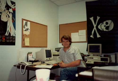 My at work in the ComputorEdge editorial offices, sometime in July 1988. The computer on the left is my writing computer. The one on the right is a two-modem BBS.